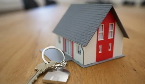Model house next to a set of keys on a wooden table